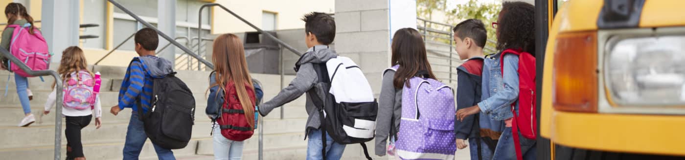 Elementary school kids arrive at school from the school bus