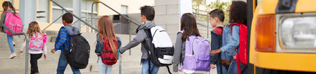 Elementary school kids arrive at school from the school bus